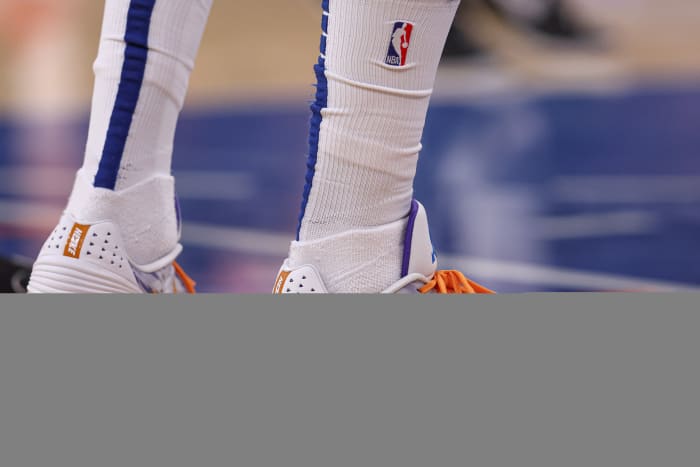 A view of white and orange Nike shoes.